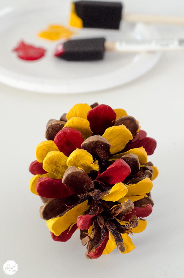 red and yellow painted pinecone for a pinecone turkey craft